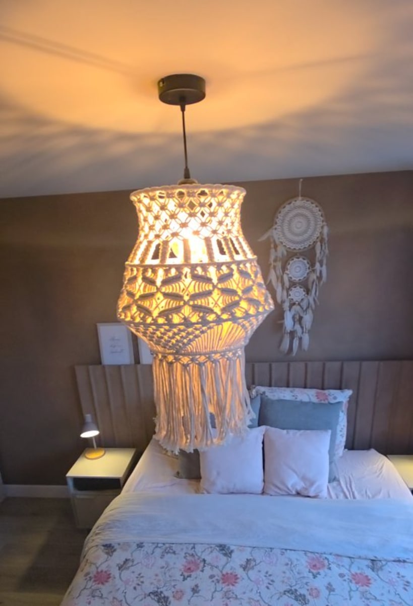 Slaapkamer met een wand in warme betonlook achter het bed
