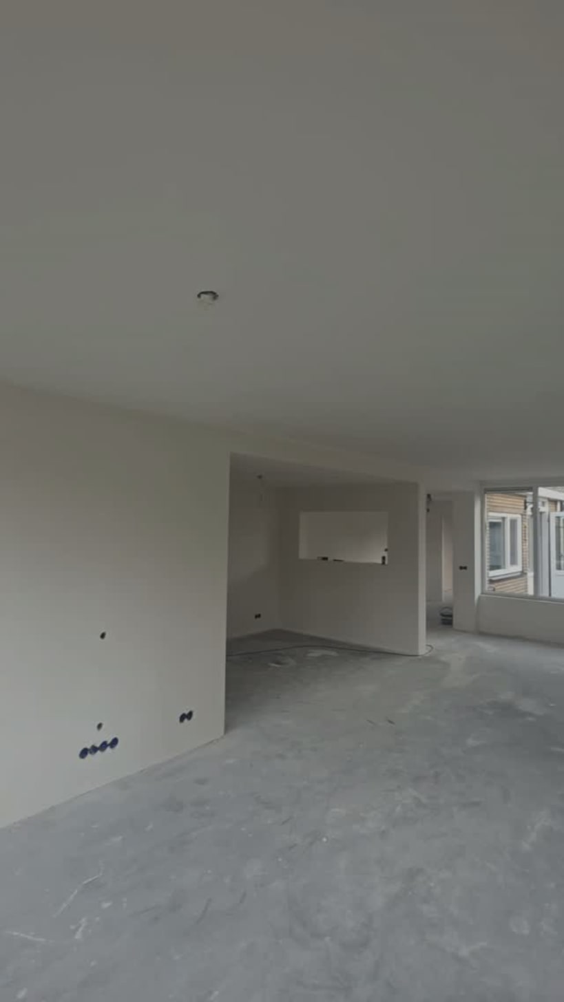 Lege woonkamer met egaal wit gespoten wanden en plafond